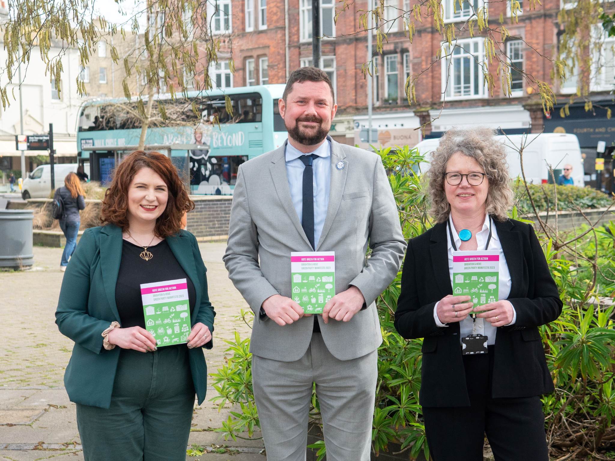Picture of councillors Hannah Allbrooke, Phelim MacCafferty and Siriol Hugh-Jones holding the manifesto in front of Hove Town Hall