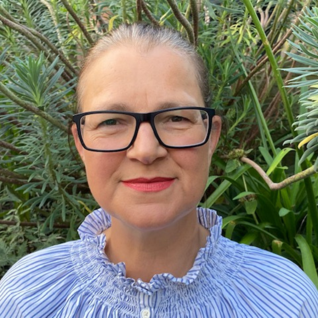 A photo of Councillor Kerry Pickett, in a blue and white striped top, wearing glasses